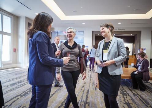 An employee talks with other conference attendees.