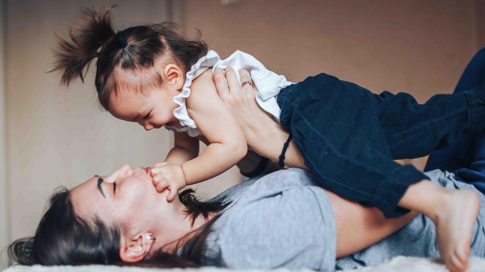 Baby and mom laying down and playing